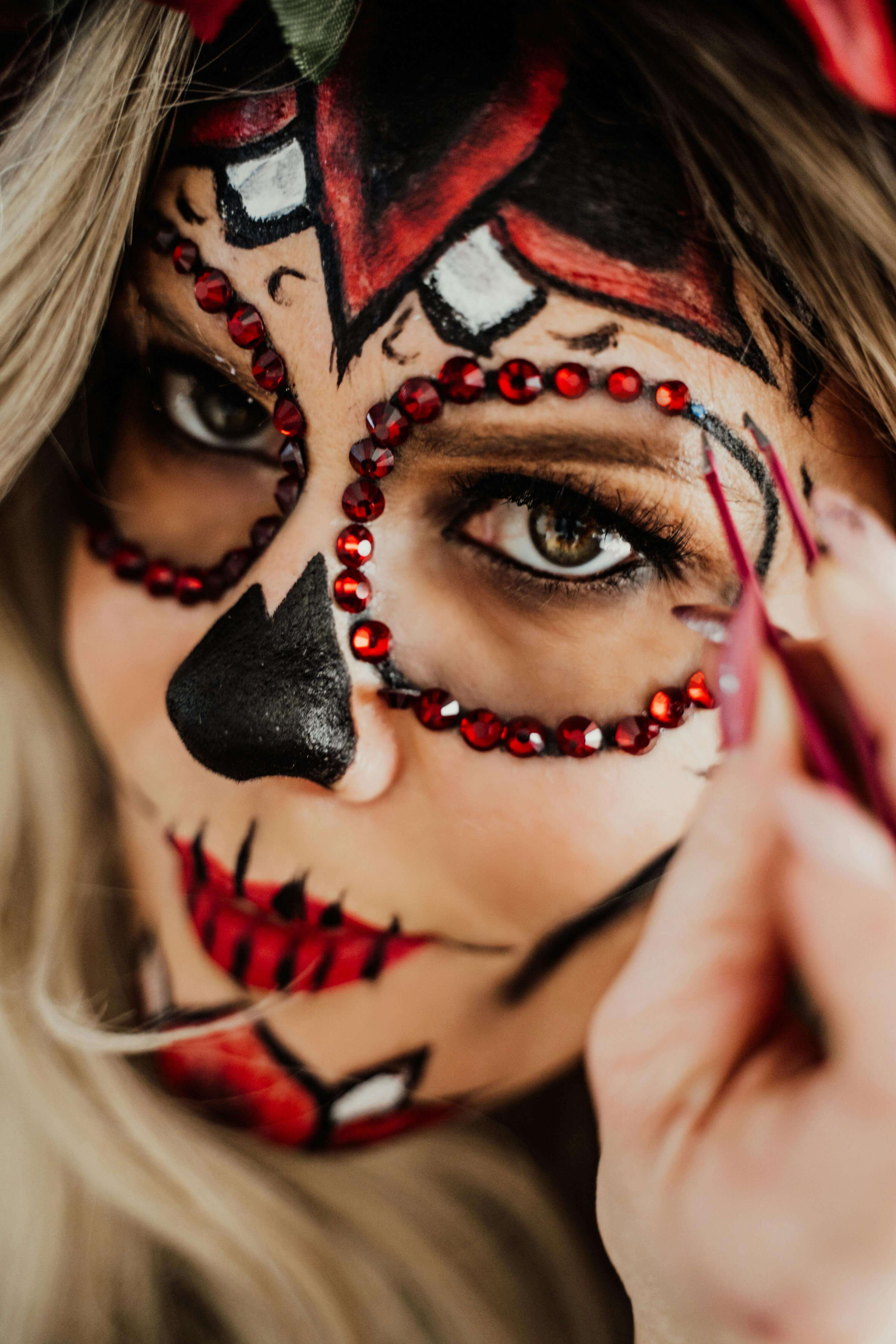 una mujer pintandose la cara de Catrina