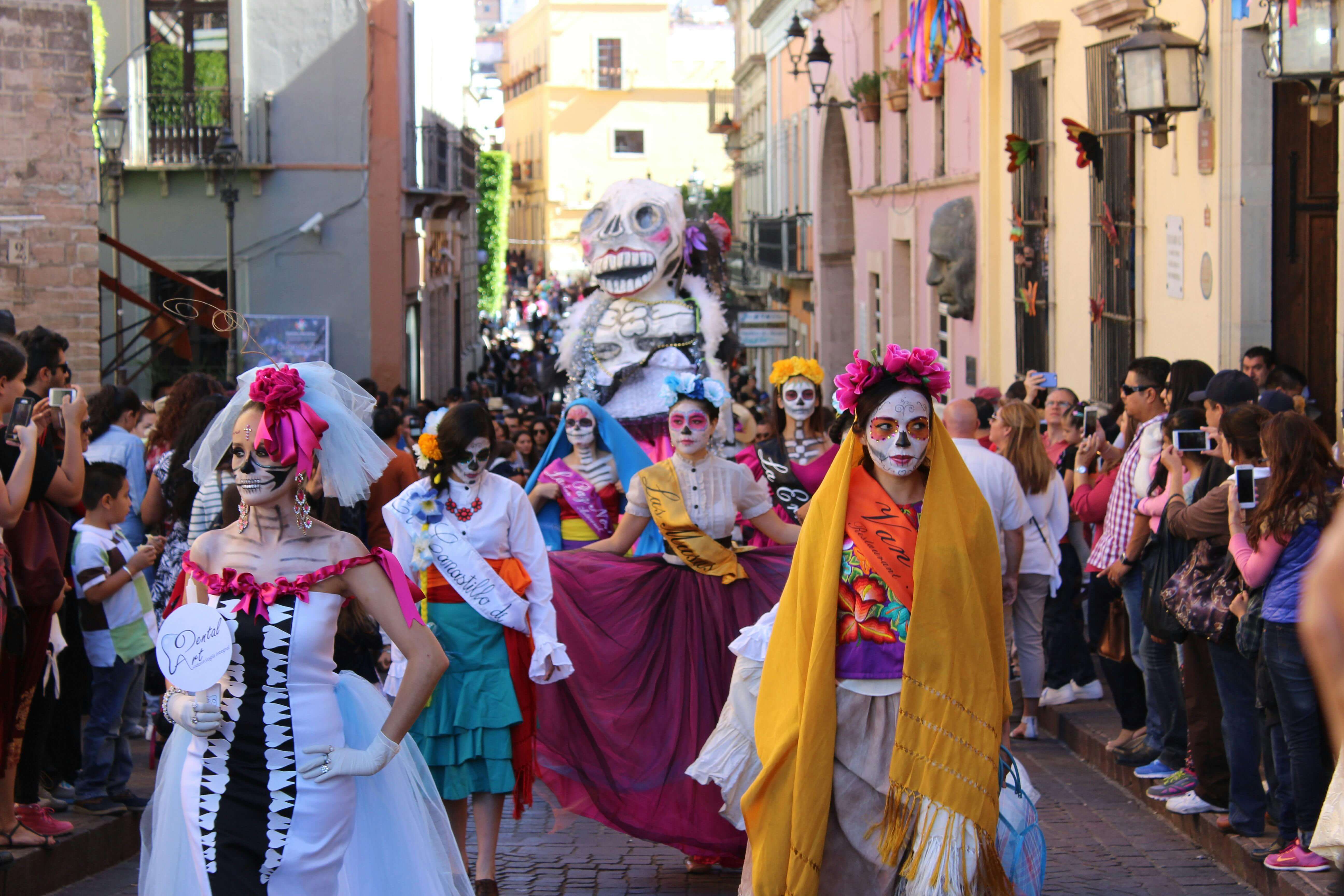 celebracion del Dia de los muertos y personas usando el maquillaje de Catrina