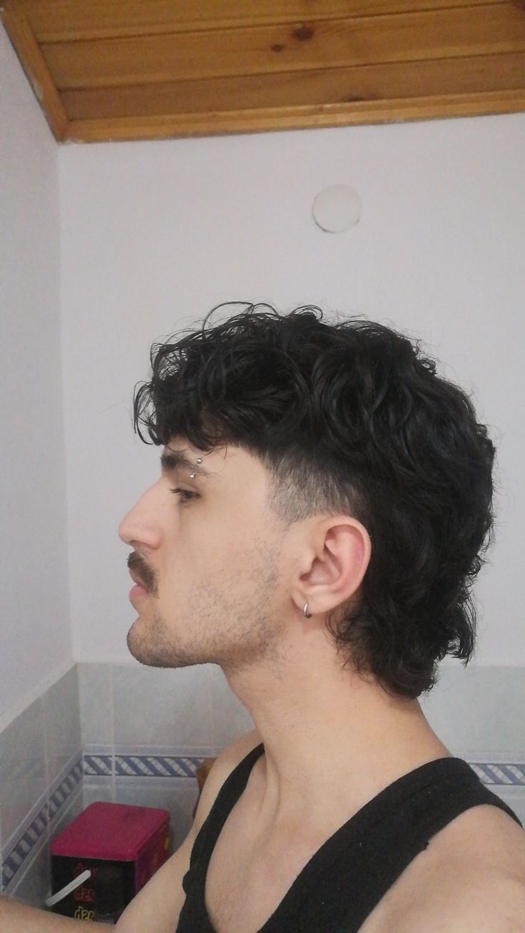 Mann mit lockigem Mullet und rasierten Seitenprofil