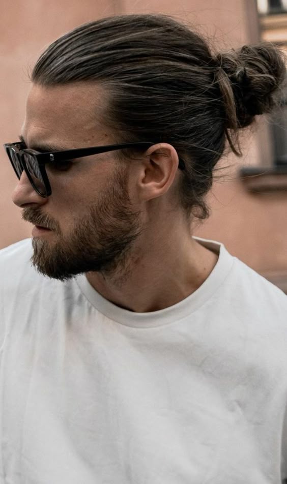 Mann mit Man Bun, Bart und Sonnenbrille in Seitenansicht