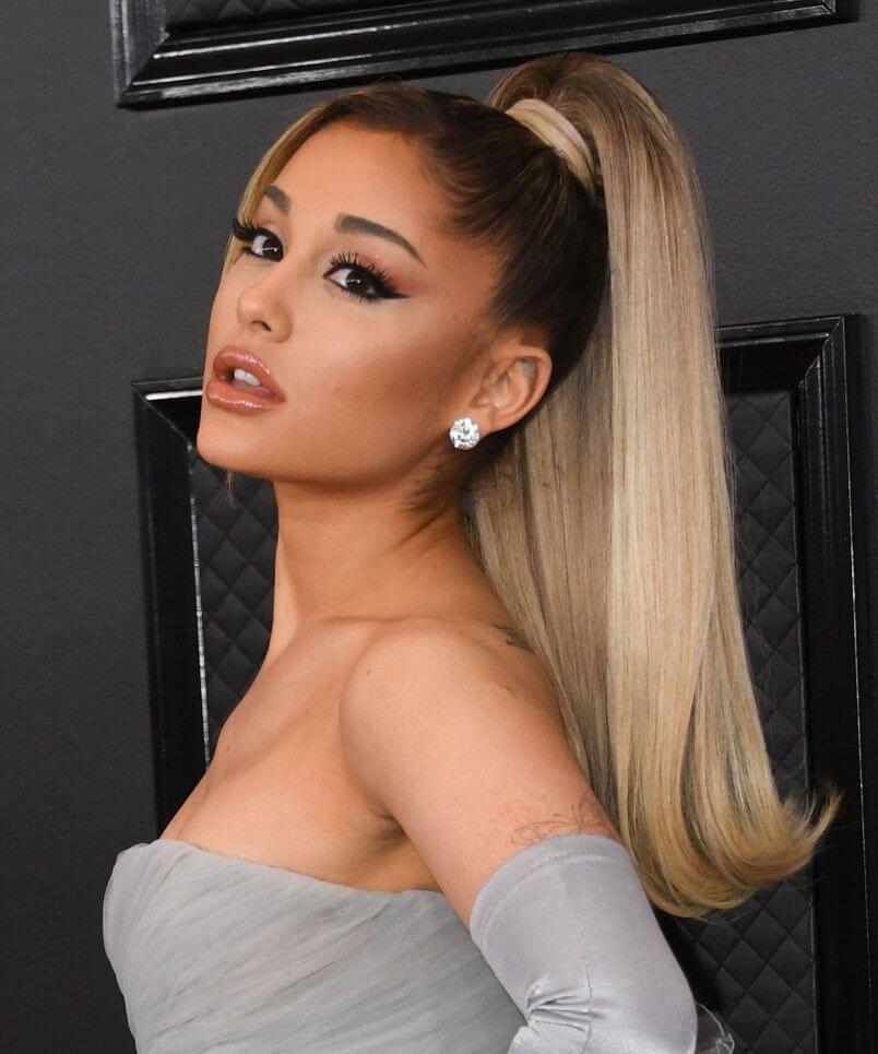 Ariana Grande com um rabo de cavalo clássico alto, uma ideia de penteado para escola.