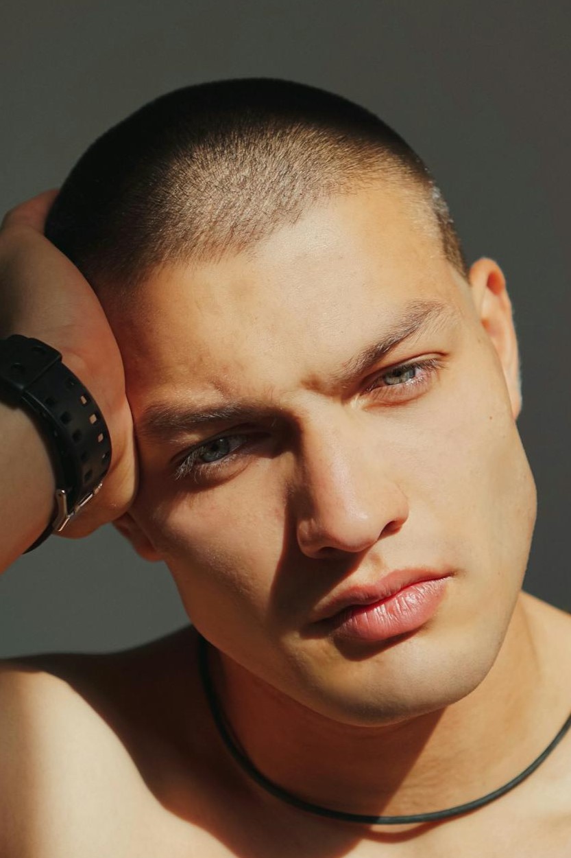 Nahaufnahme eines Mannes mit einem Buzz Cut, eine markante Kurzhaarfrisur, die auch bei dünnem Haar geeignet ist.