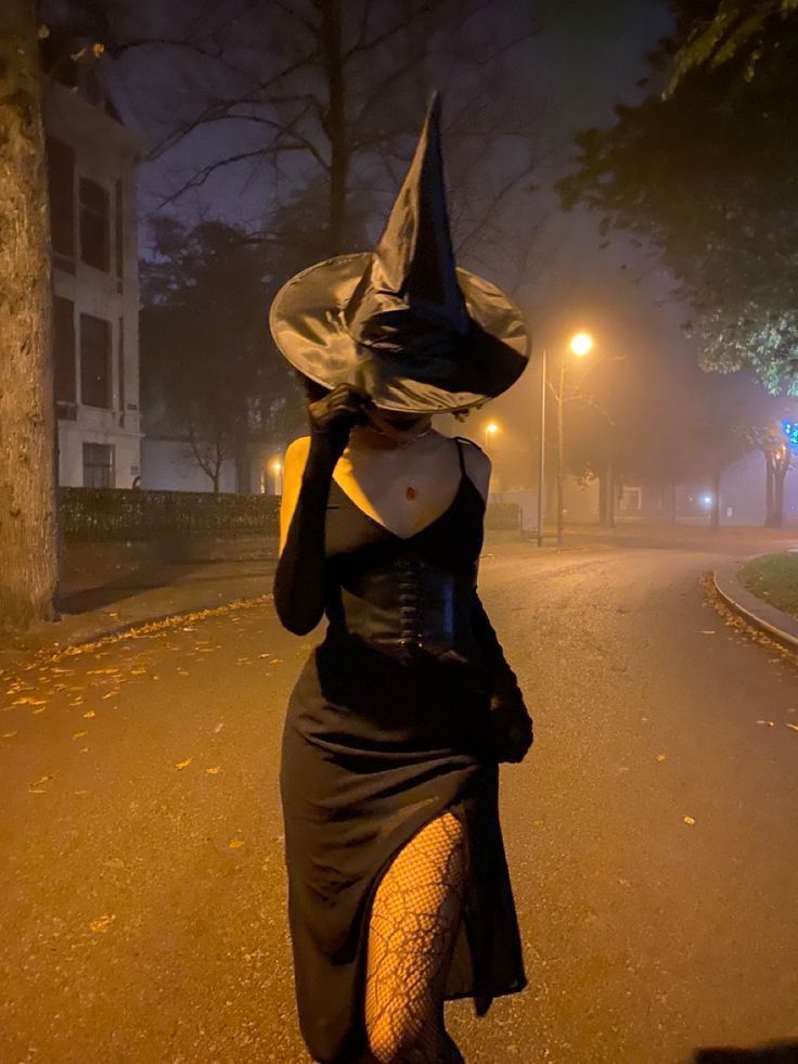 Frau in einem modernen, eleganten Hexenkostüm, eine stilvolle Halloween-Verkleidung.