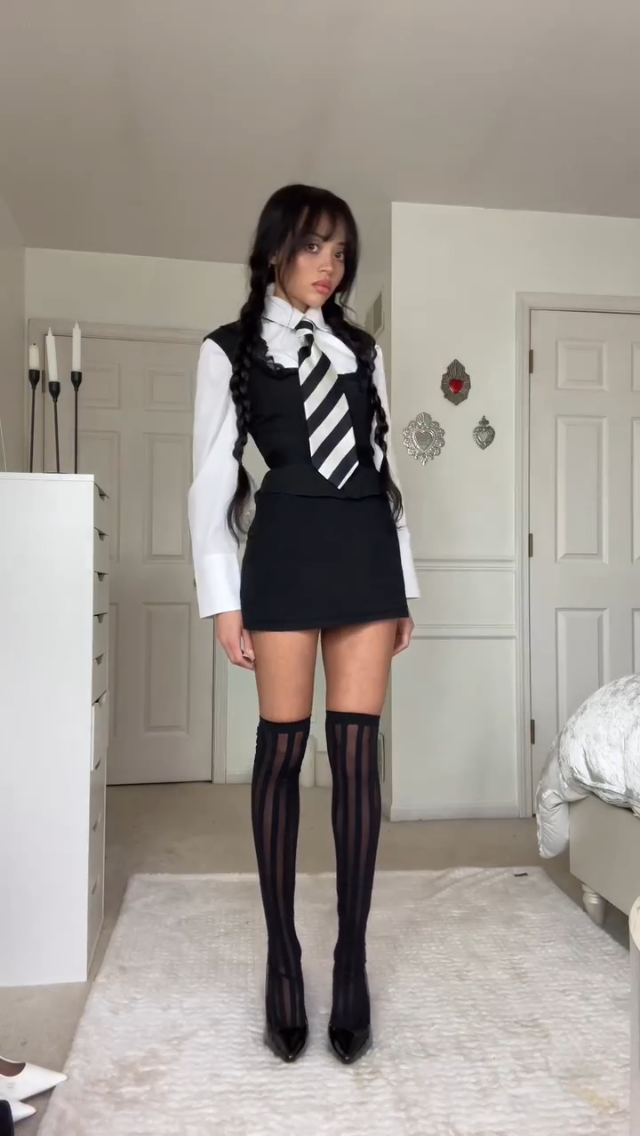 Frau im Wednesday Addams Kostüm aus der Netflix-Serie, eine trendige Halloween-Idee.
