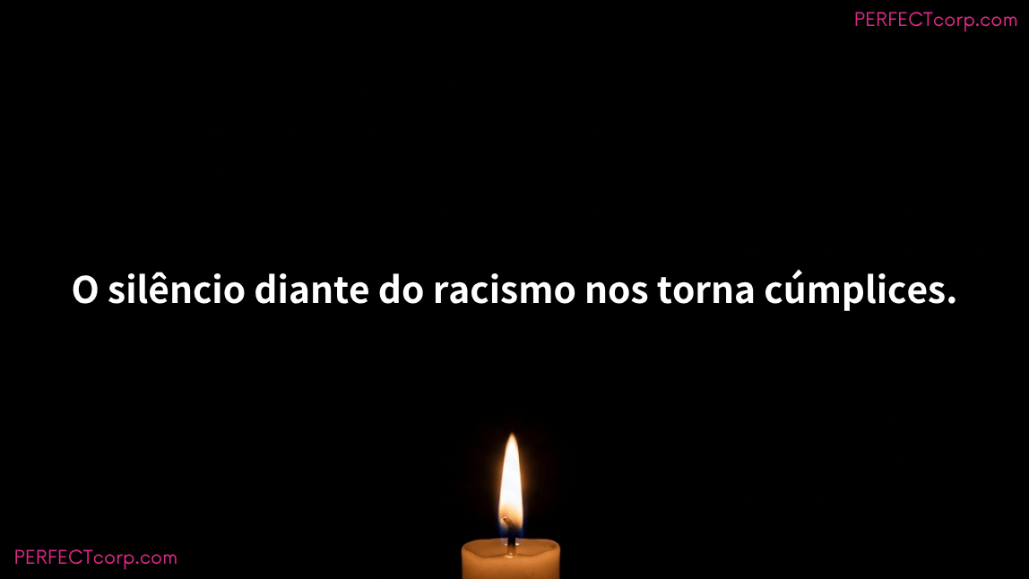 Uma vela acesa em fundo escuro, simbolizando esperança e memória, com a frase antirracista: "O silêncio diante do racismo nos torna cúmplices", para reflexão no Dia da Consciência Negra.