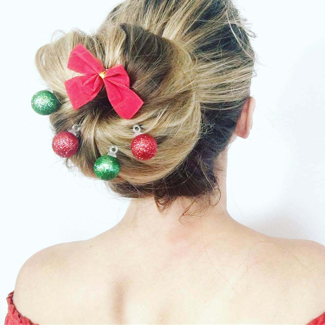 Eine Frau mit einer eleganten Dutt-Frisur, die mit kleinen Weihnachtskugeln geschmückt ist.