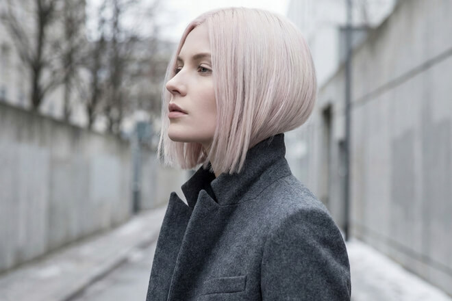 Der Haarfarben-Trend "Winter Blush Blond": Eine Frau mit einem modernen, kühlen Bob in einem eisigen Blond mit einem Hauch von Rosé.