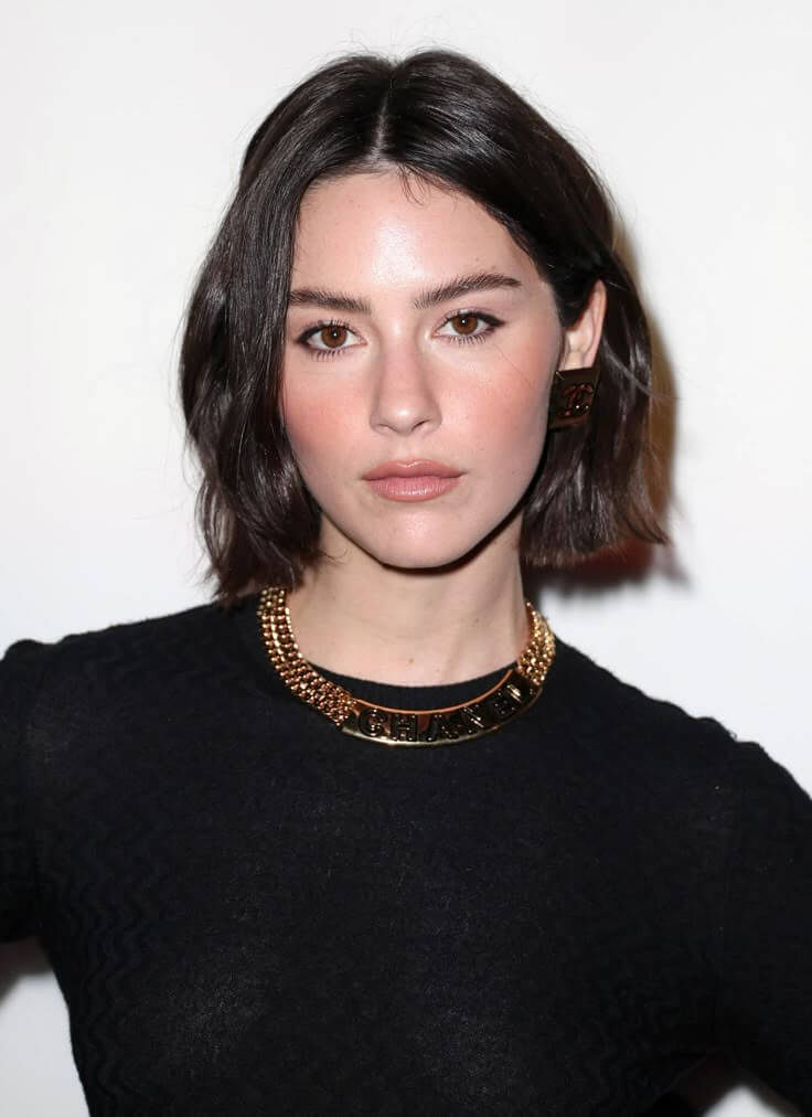 Mulher com cabelo preto estilo bob curto, tendência de corte feminino 2026.