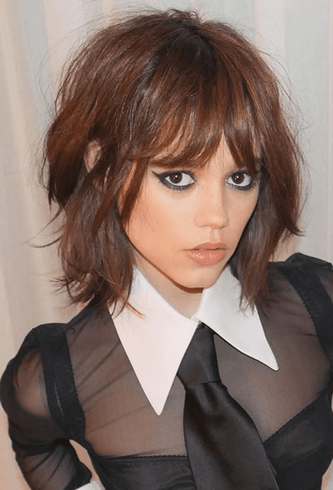 Mulher com corte de cabelo shaggy bob e franja, tendência de cabelo curto 2026 despojado.