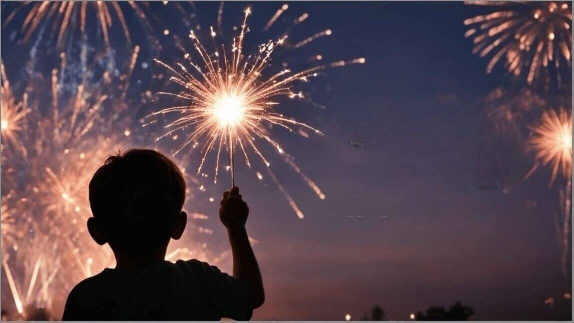 Boy holds a sparkler up, with fireworks in the background.