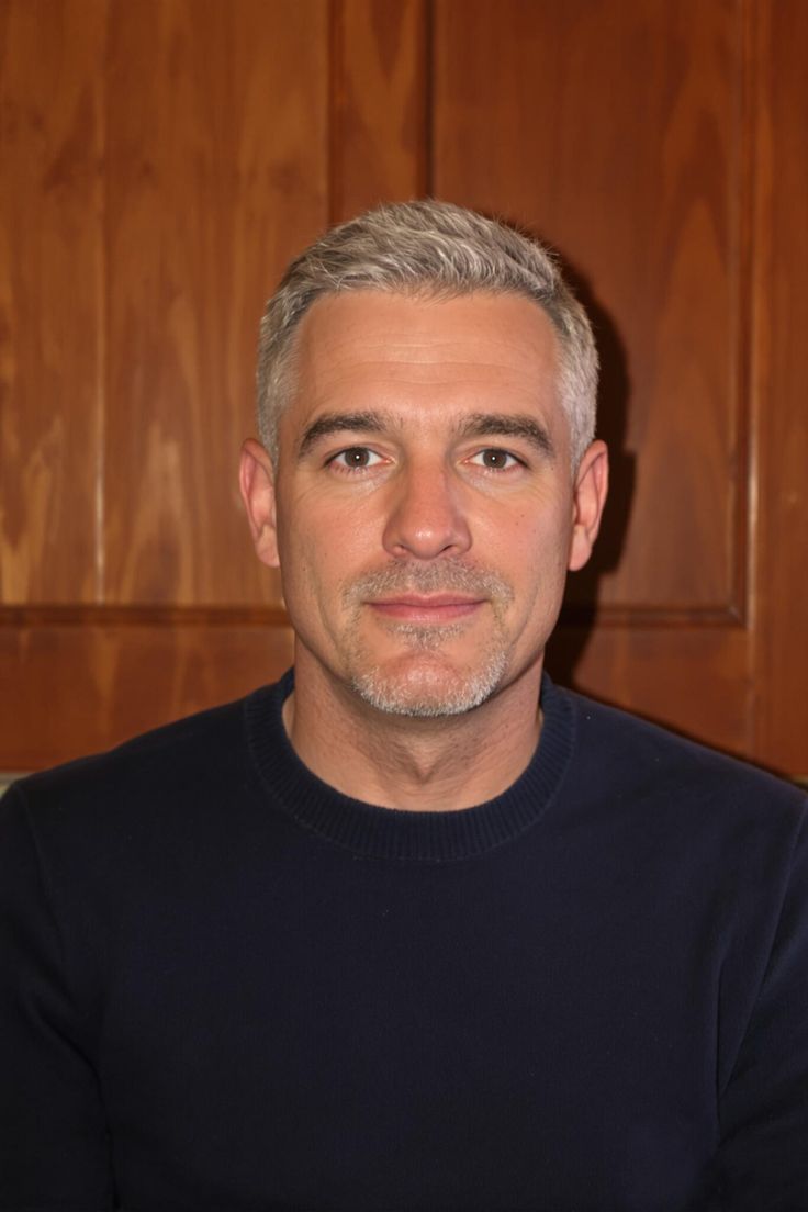 This may contain: a man in a black sweater is looking at the camera