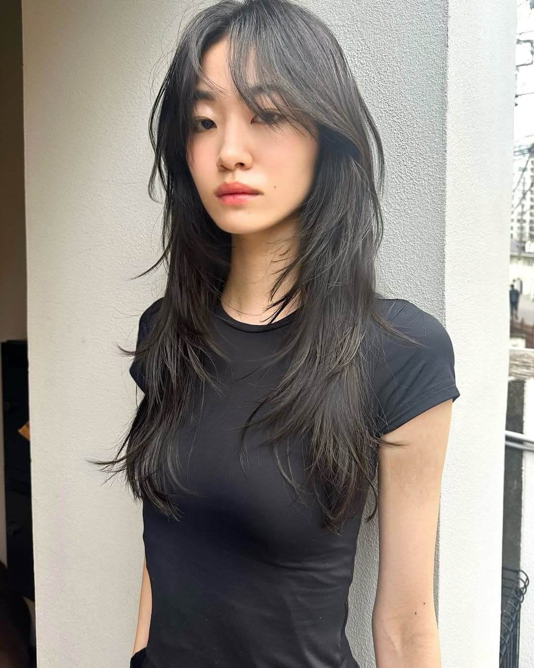 顔周りにレイヤーが入り黒髪でも垢抜けて見えるロングヘアの女性