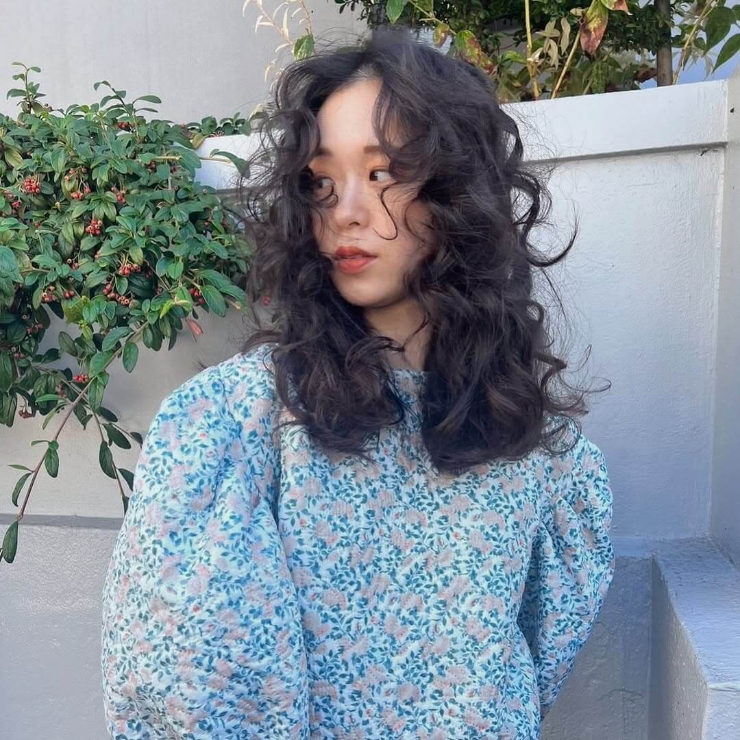 黒髪でも垢抜けるウェーブパーマスタイルの女性