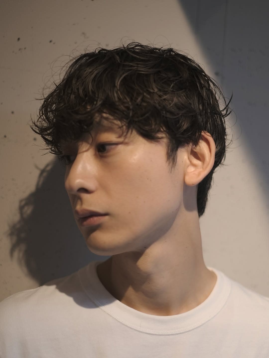 前髪を下ろしたニュアンスパーマのメンズショートヘア 前髪を下ろしたニュアンスパーマのメンズショートヘア