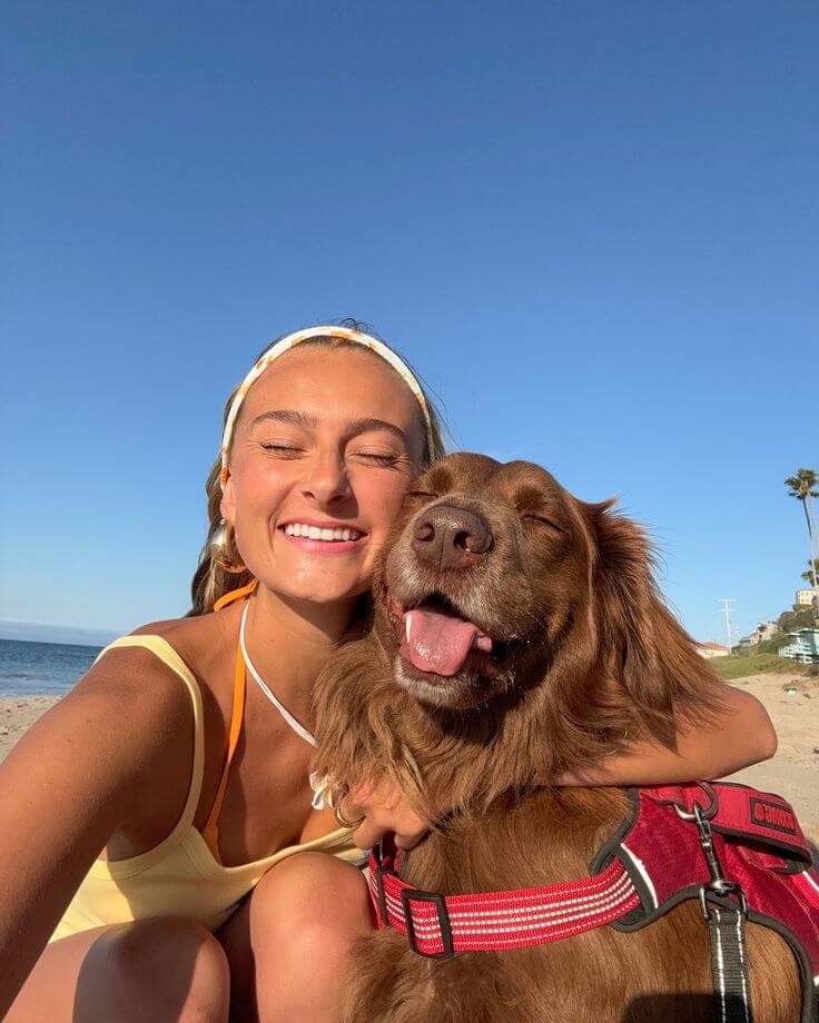 Cette image peut contenir : une femme qui enlace son chien sur la plage