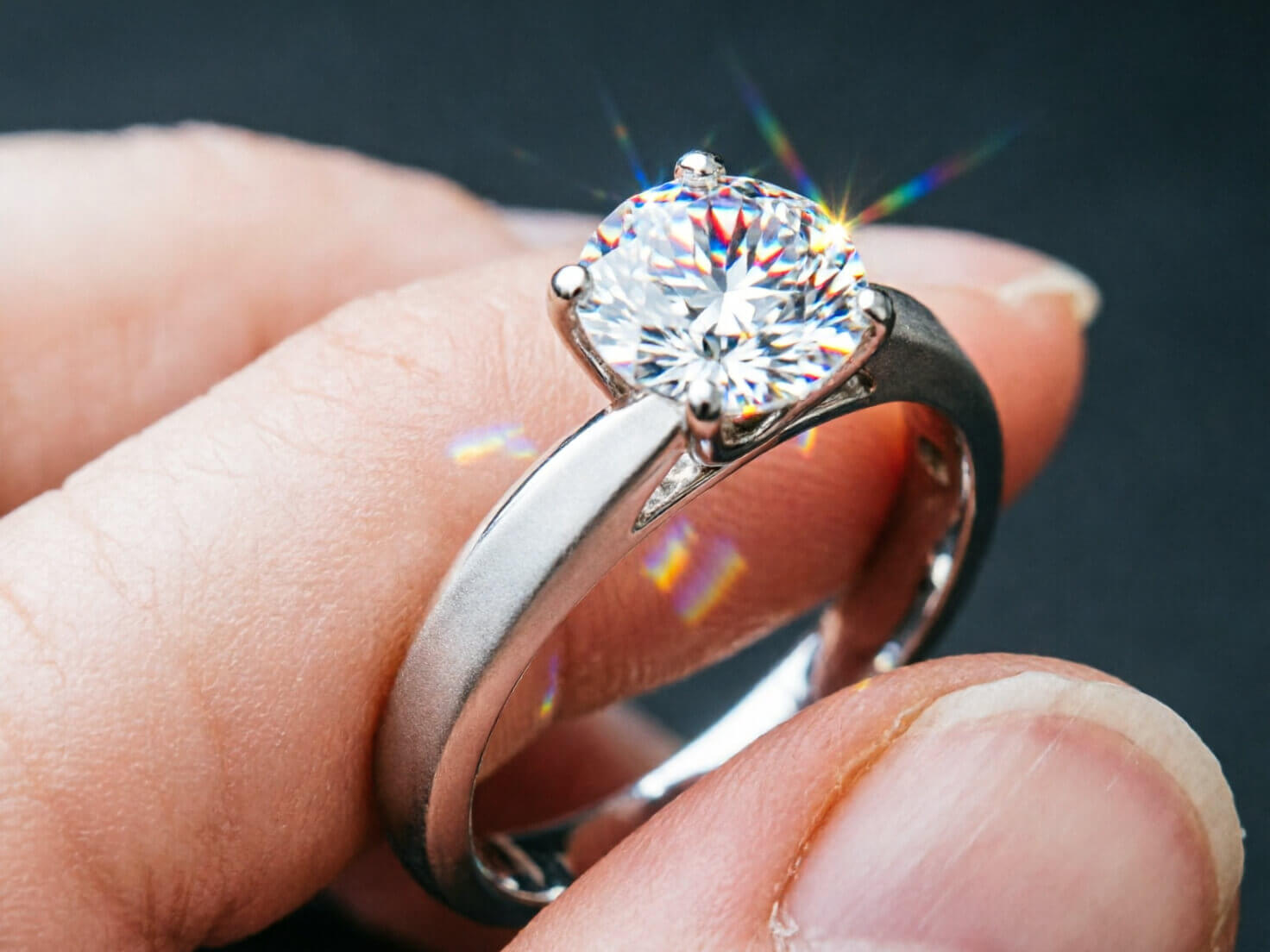 Realistic Lighting Photorealistic extreme close-up of a diamond engagement ring on a finger, light catching the facets with realistic sparkle and refraction, soft directional studio lighting highlighting metal reflections, high-end jewelry photography style