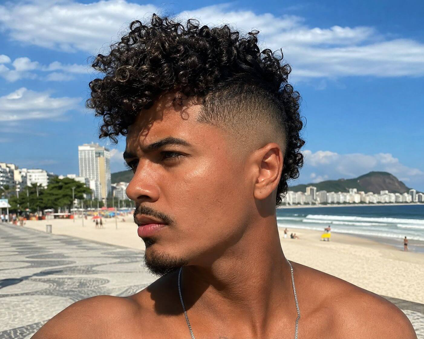Homem brasileiro com moicano cacheado e laterais em degradê