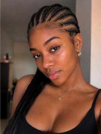 Mulher negra com tranças nagô laterais e cabelo crespo solto