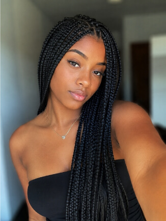 Mulher negra com box braids longas e acabamento volumoso