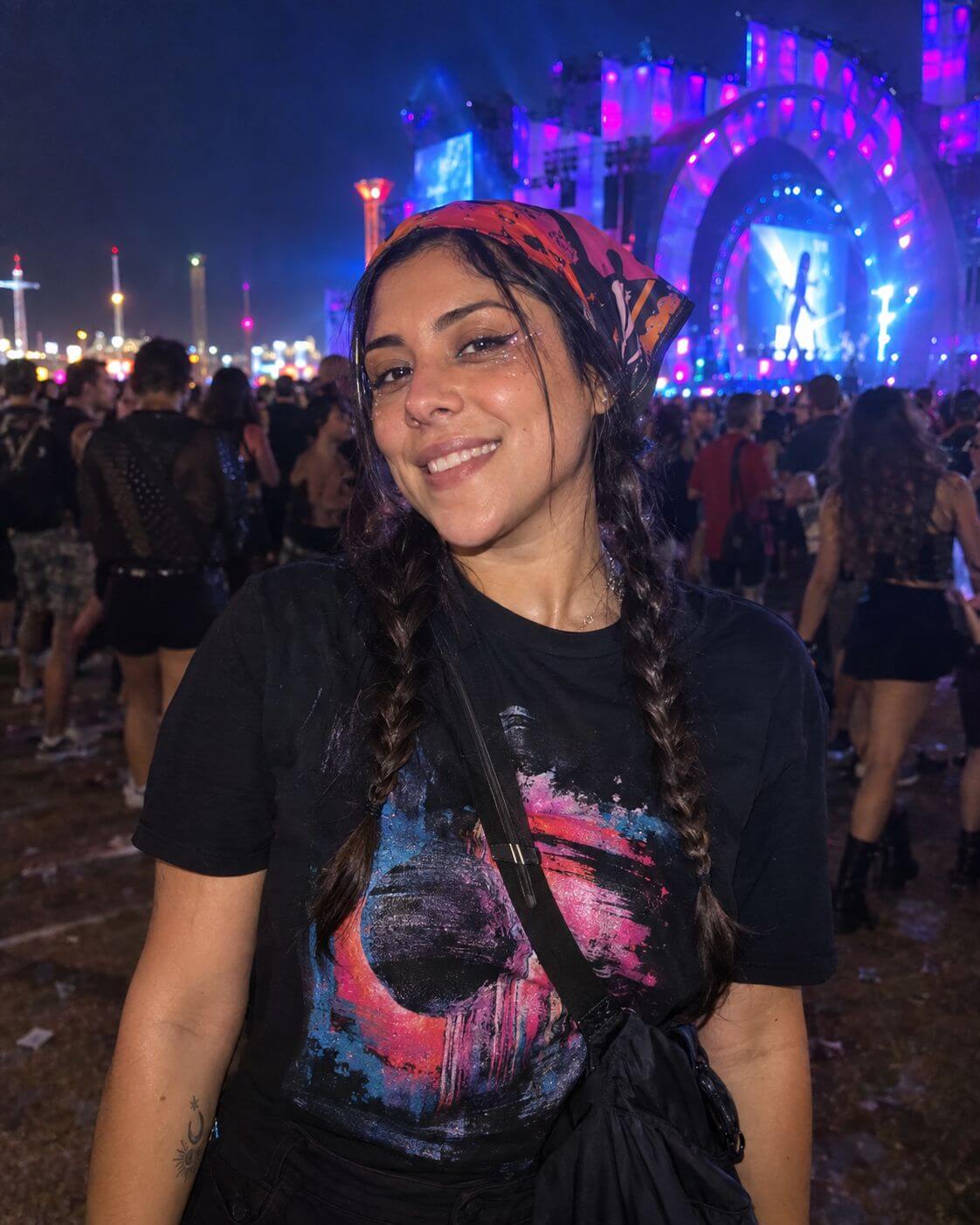 Mulher brasileira sorrindo após um festival, com maquiagem brilhante, tranças e bandana.