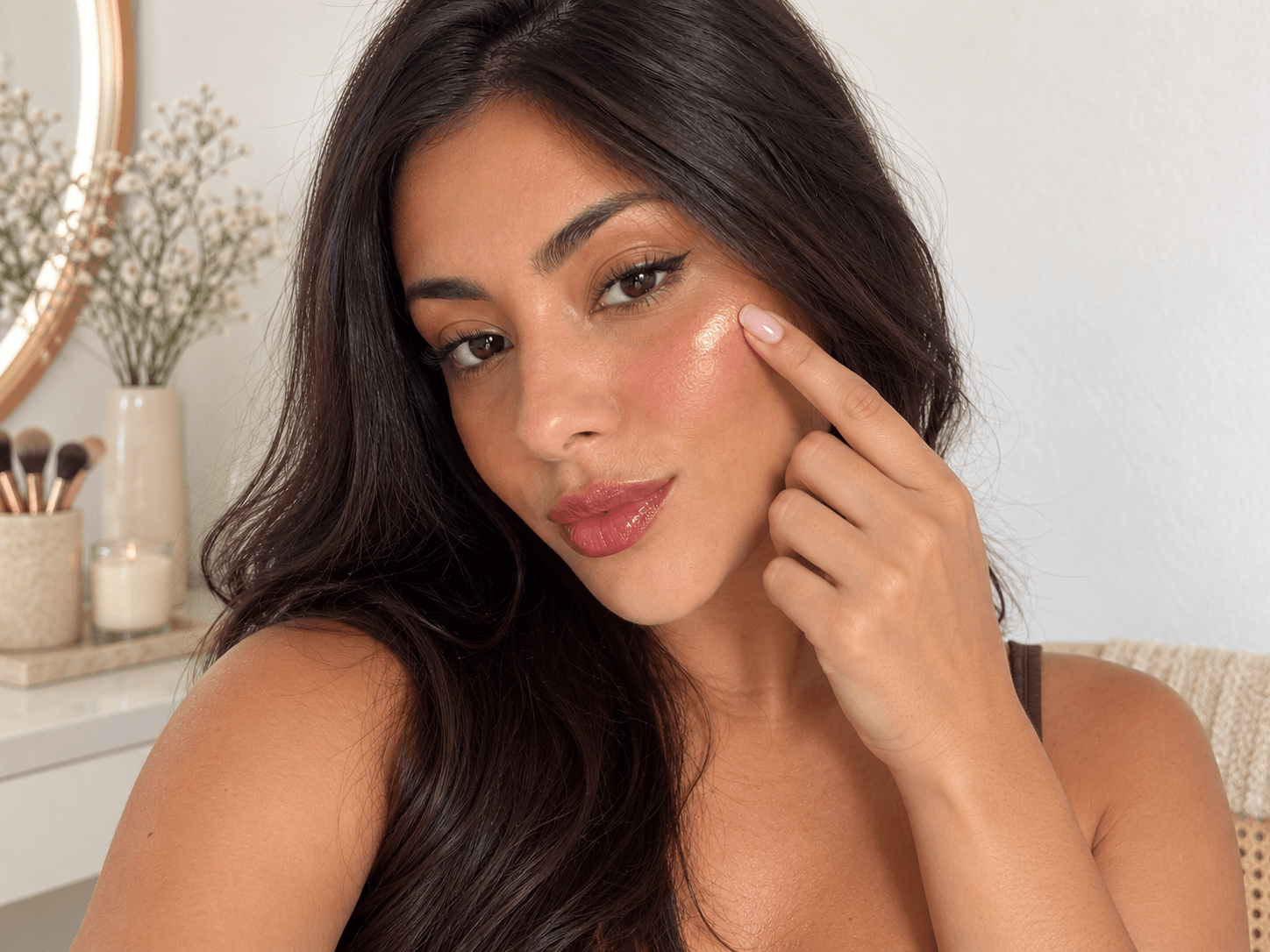 Aplicação de iluminador líquido para criar uma pele glow natural.