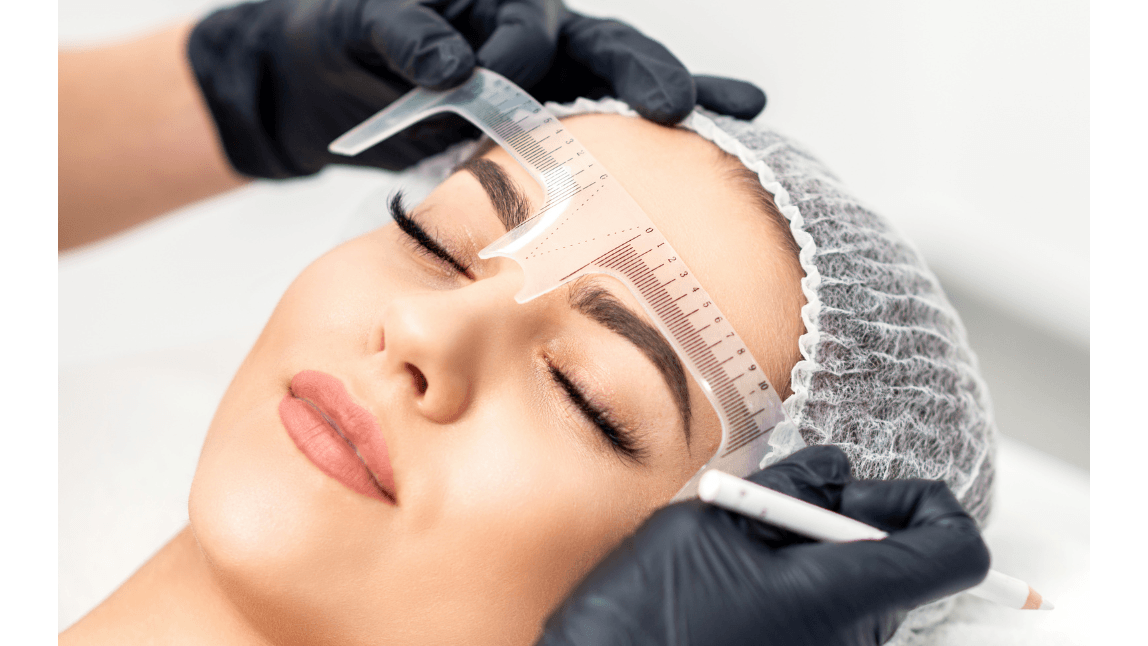 A close-up of a woman having her eyebrows threaded by a stylist in a beauty salon. A close-up of a woman having her eyebrows threaded by a stylist in a beauty salon.