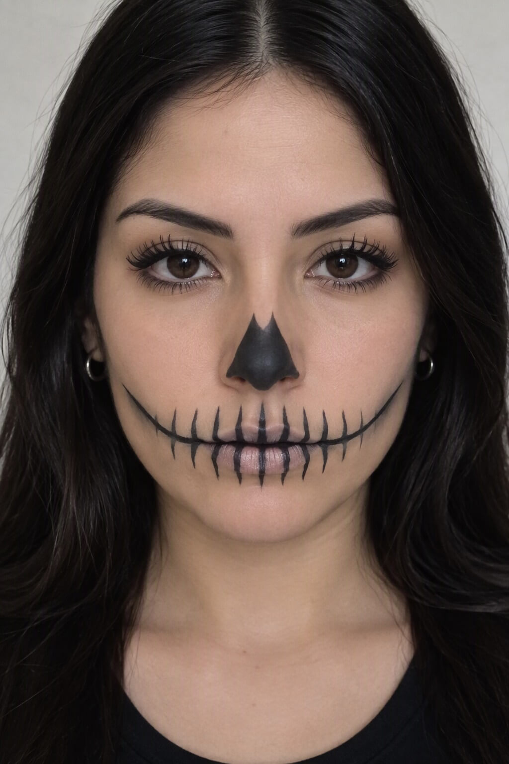 Boca de calavera: Maquillaje de boca de calavera con líneas negras verticales sobre los labios
