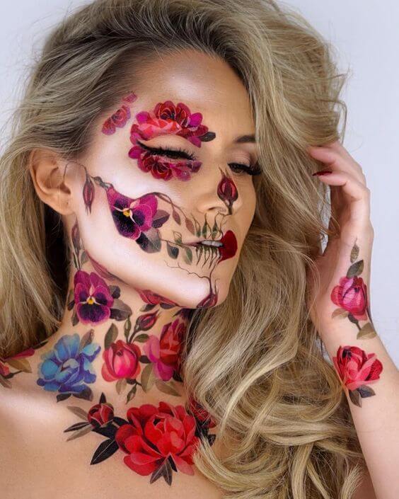 Catrina con flores: Maquillaje de catrina con flores de cempasúchil y rosas pintadas en la frente