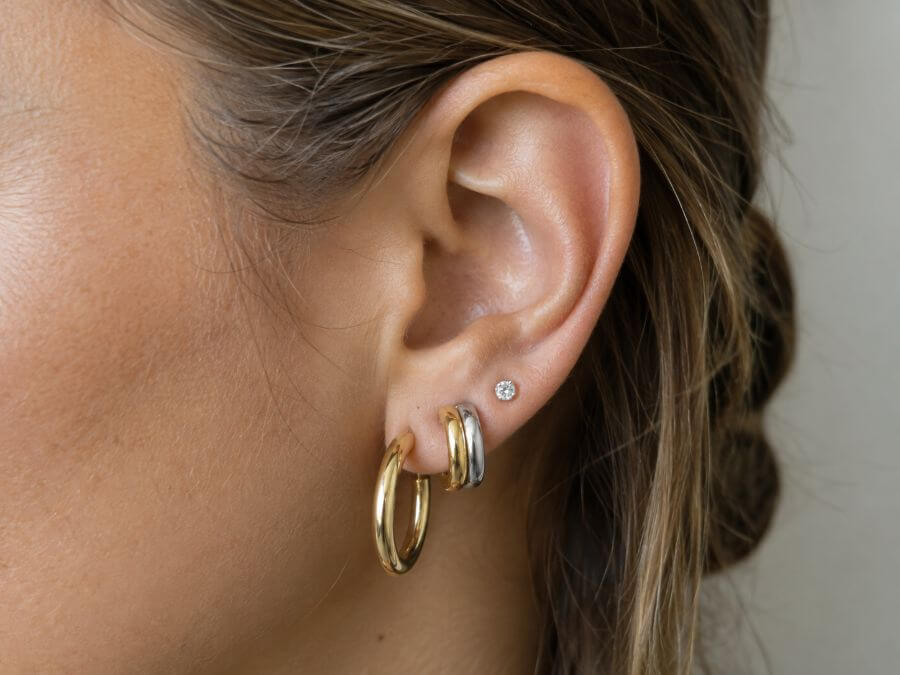 Mixed metal ear stack with a two tone huggie bridging gold and silver
