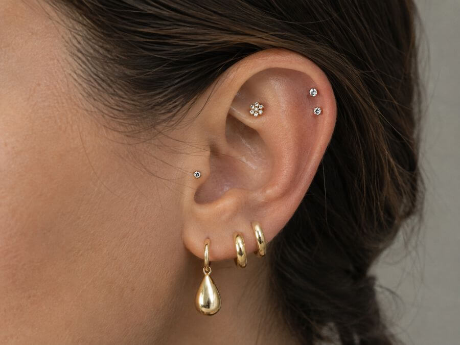 Full curated ear with drop, huggies, flat, tragus and forward helix studs