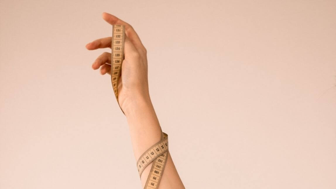 Arm entwined with measuring tape