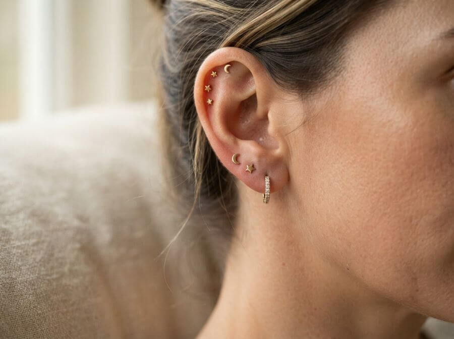 Celestial ear stack with star and moon studs and a diamond huggie